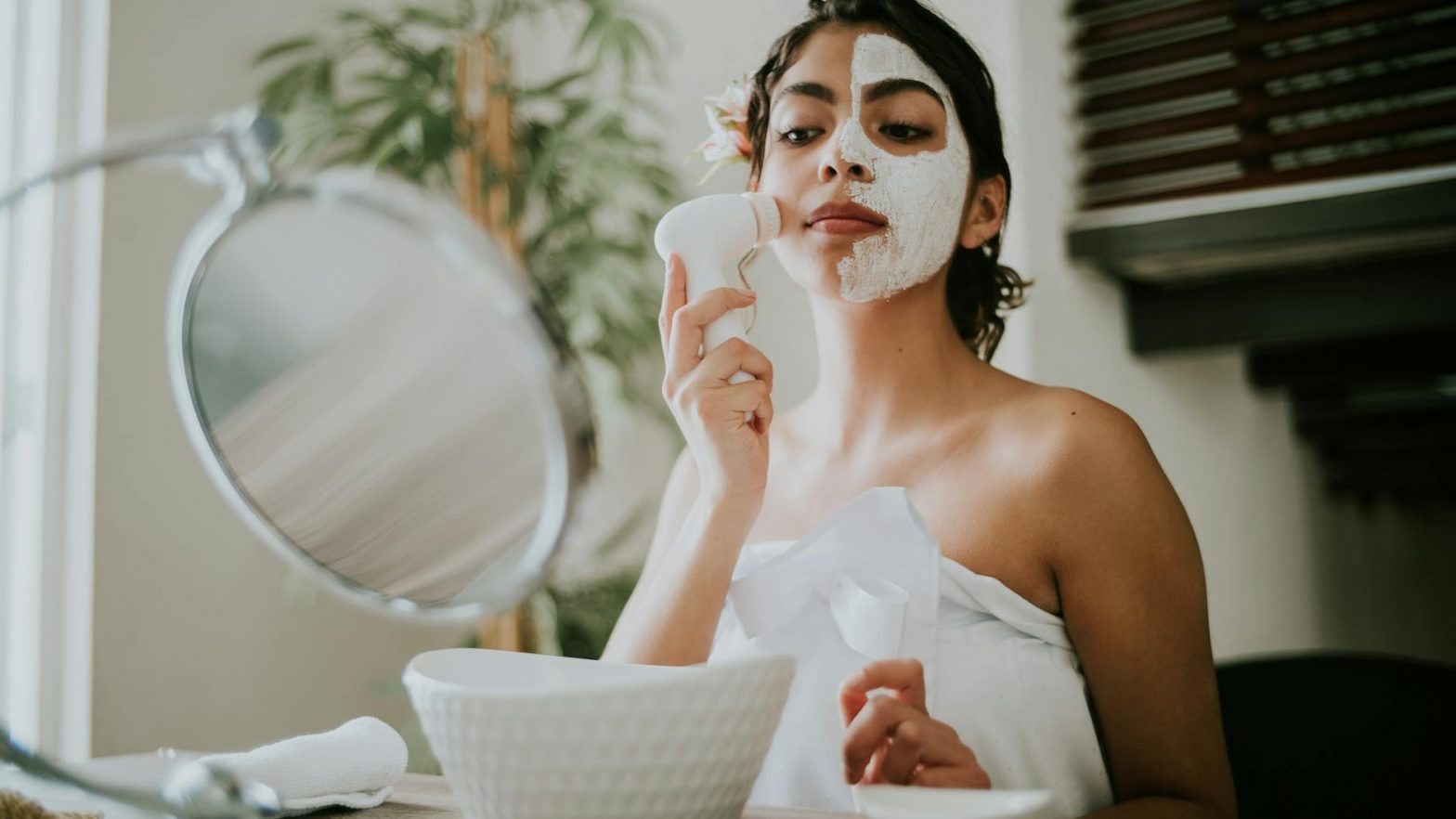 woman in white tube top holding white facial cleanser